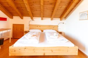 a wooden bed in a room with a wooden ceiling at Bergzitt in Ofterschwang