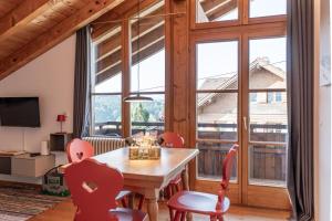 a dining room with a table and chairs and a large window at Bergzitt in Ofterschwang