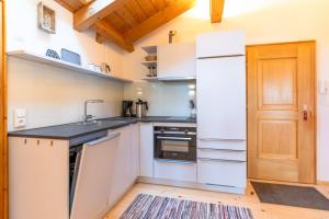 a kitchen with white appliances and a wooden door at Bergzitt in Ofterschwang