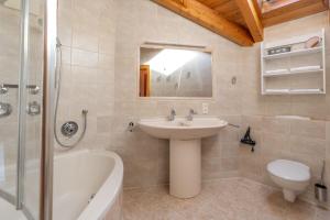 a bathroom with a sink and a tub and a toilet at Bergzitt in Ofterschwang +2 photos