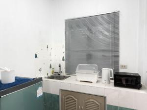 a kitchen with a sink and a window and a microwave at RJJhouse Kohphangan in Ban Nua +14 photos