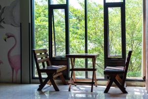 a table and two chairs in front of a window at BB House Rambuttri2 บีบี เฮ้าส์ รามบุตรี2 in Bangkok