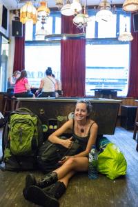 una donna seduta sul pavimento con i suoi bagagli di The Flying Pig Downtown ad Amsterdam
