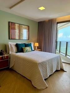 a bedroom with a large bed with a large window at Refuge Beira Mar - Boa Viagem in Recife +32 photos