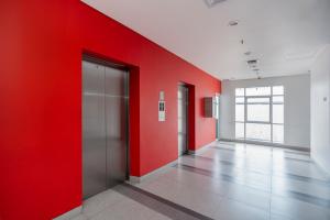 an empty hallway with red walls and a door at JP Hotel Pluit Jakarta by LIFE in Jakarta