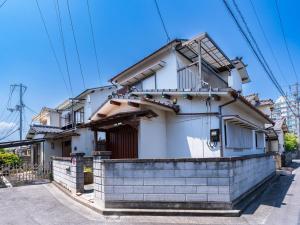 a white house with a brick wall in front of it at 屋島base-最大10名 in Takamatsu