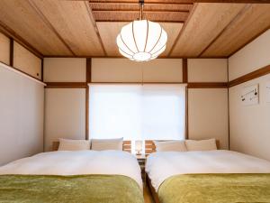 two beds in a room with a large window at 屋島base-最大10名 in Takamatsu