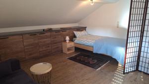 a small bedroom with a bed and wooden cabinets at Sunset Apartment in Grafenwöhr
