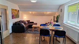 a living room with a couch and a table and chairs at Sunset Apartment in Grafenwöhr