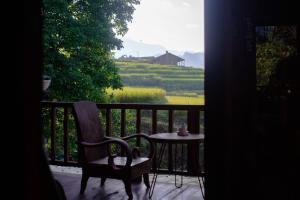 a chair and a table on a balcony with a view at Sapa Ta Van Desi House - Mountain View & Hiking Tours in Sapa