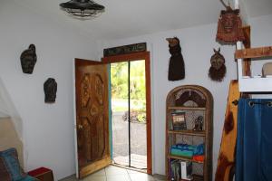 a room with a door and some items on the wall at Sweet Spot Stay - Tropical TreeTops Home in Pahoa