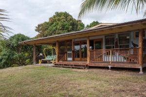 a house with a porch with a swing at Sweet Spot Stay - Tropical TreeTops Home in Pahoa