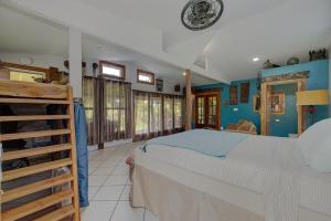 a bedroom with a large bed and blue walls at Sweet Spot Stay - Tropical TreeTops Home in Pahoa