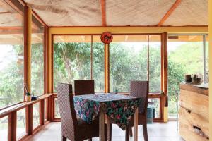 a dining room with a table and chairs on a balcony at Sweet Spot Stay - Tropical TreeTops Home in Pahoa