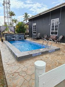 a swimming pool in front of a house at Penarik baru homestay in Kampung Penarik