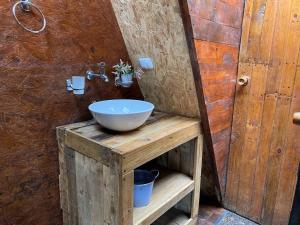 a bathroom with a bowl sink on a wooden stand at Nido Bag Glamping in Cali