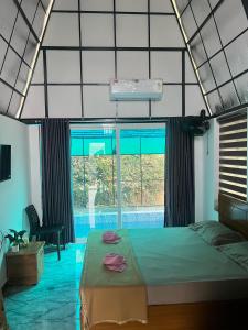 a bedroom with a bed and a swimming pool at Zerahs Private Pool Villa, Athirappilly - Extra upstair Bed space in Athirappilly
