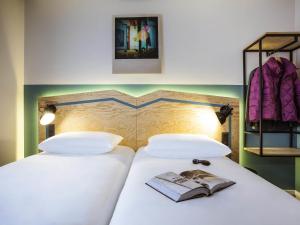 a bedroom with a bed with a book on it at ibis Styles Paris Nation Porte De Montreuil in Paris