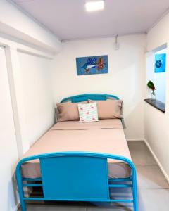 a bed in a small room with a blue frame at Boho Pelicano in Bocas Town