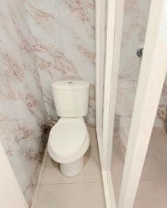 a white toilet in a bathroom with marble walls at Boho Pelicano in Bocas Town +22 photos