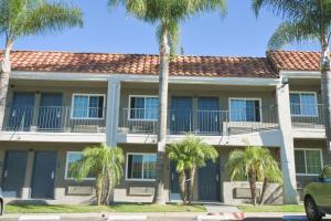a building with palm trees in front of it at Welcome Inn Corona in Corona