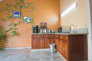 a kitchen with a sink and a counter top at Welcome Inn Corona in Corona