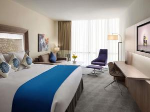 a hotel room with a large bed and a couch at Novotel Jeddah Tahlia in Jeddah +117 photos