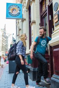 un homme et une femme debout à l'extérieur d'un bâtiment dans l'établissement The Flying Pig Downtown, à Amsterdam