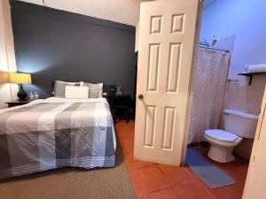 a bedroom with a bed and a bathroom with a toilet at Los Portones de Ataco in Concepción de Ataco +12 photos