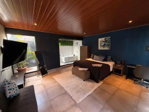 a bedroom with blue walls and a bed and a couch at Los Portones de Ataco in Concepción de Ataco