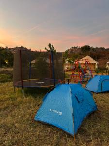 two tents in a field with a playground at Aura Resort and Restaurant in Chikalthān