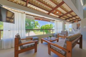 a living room filled with furniture and a large window at Casa Maravida in Maragogi