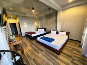 a hotel room with two beds and a television at Aroma Holiday Home-Haputhale in Haputale