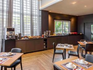 a restaurant with tables and chairs and a kitchen at Mercure Sao Bernardo Do Campo in São Bernardo do Campo