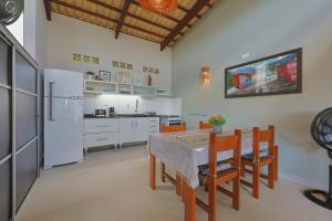 a kitchen with a table and chairs and a refrigerator at Casa Maravida in Maragogi