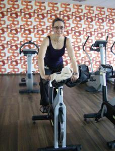 a woman sitting on a exercise bike in a gym at Gutshof Ziegelhütte in Edenkoben