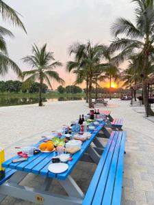 a group of blue picnic tables on the beach at Luxury 1BR Apartment - Ocean Lake View - Vinhomes Ocean Park in Gia Lâm Pho