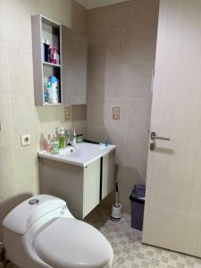 a bathroom with a white toilet and a sink at Apartment In Central Jakarta in Jakarta