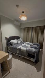 a bedroom with a bed and a chandelier at Apartment In Central Jakarta in Jakarta