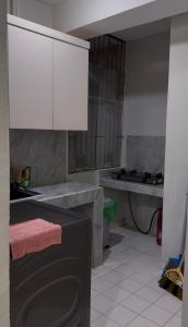 a kitchen with a sink and a white cabinet at Apartment In Central Jakarta in Jakarta