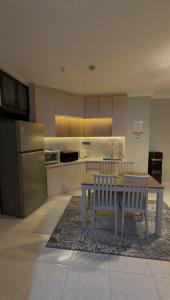 a kitchen with a table and two chairs and a refrigerator at Apartment In Central Jakarta in Jakarta