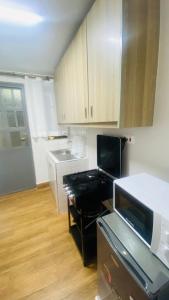 a small kitchen with a stove and a microwave at Urban Host Buru Prime 1BR Luxe in Nairobi