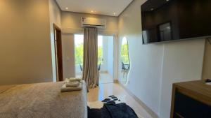 a bedroom with a bed and a sliding glass door at Flat 213 Ilha Bela Alter do Chão in Alter do Chao