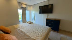 a bedroom with a bed and a flat screen tv at Flat 213 Ilha Bela Alter do Chão in Alter do Chao +38 photos