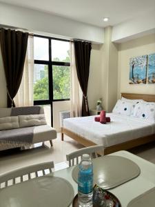 a bedroom with two beds and a table and a couch at Mactan Plains Studio Unit in Punta Engaño +26 photos