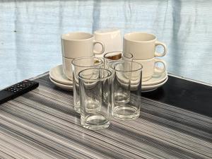 a group of glasses and cups on a table at Sameer Mountain View Glamping in Cameron Highlands