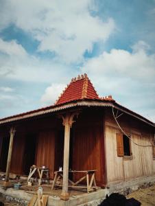 a large wooden house with a red roof at Dooz's place - Selong belanak in Selong Belanak