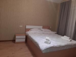 a bedroom with a bed with two white towels on it at Maia's Cottage in Bakuriani +2 photos