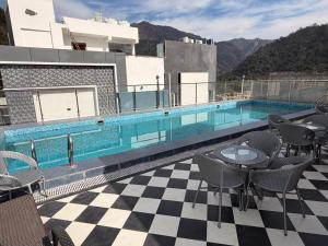 a swimming pool with tables and chairs on a building at Vyom Boutique Hotel by Aramah in Rishīkesh