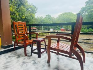 three chairs and a table on a porch with a view at Shan guest rooms in Jaffna +25 photos